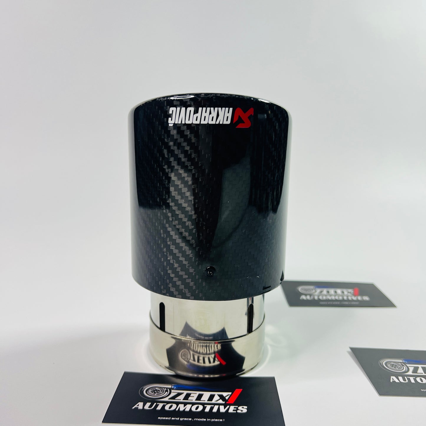 Angled perspective highlighting the carbon-fiber wrap and Akrapovic logo on the round tip