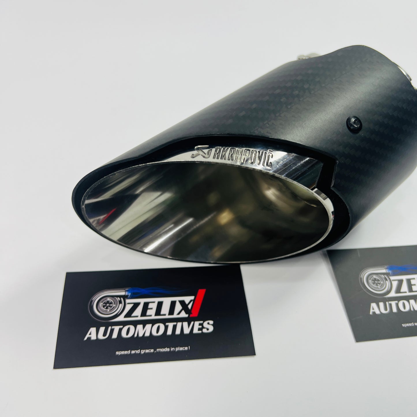 Top-down perspective emphasizing the oval outlet and uniform matte carbon texture