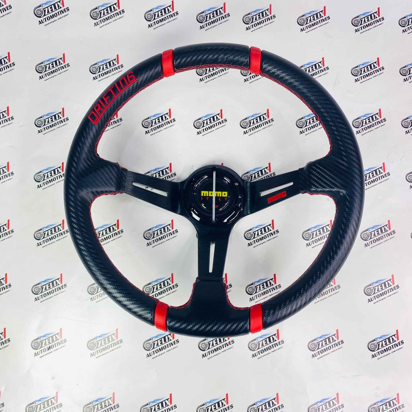 MOMO Drifting Steering Wheel with carbon fiber grip and red color accent