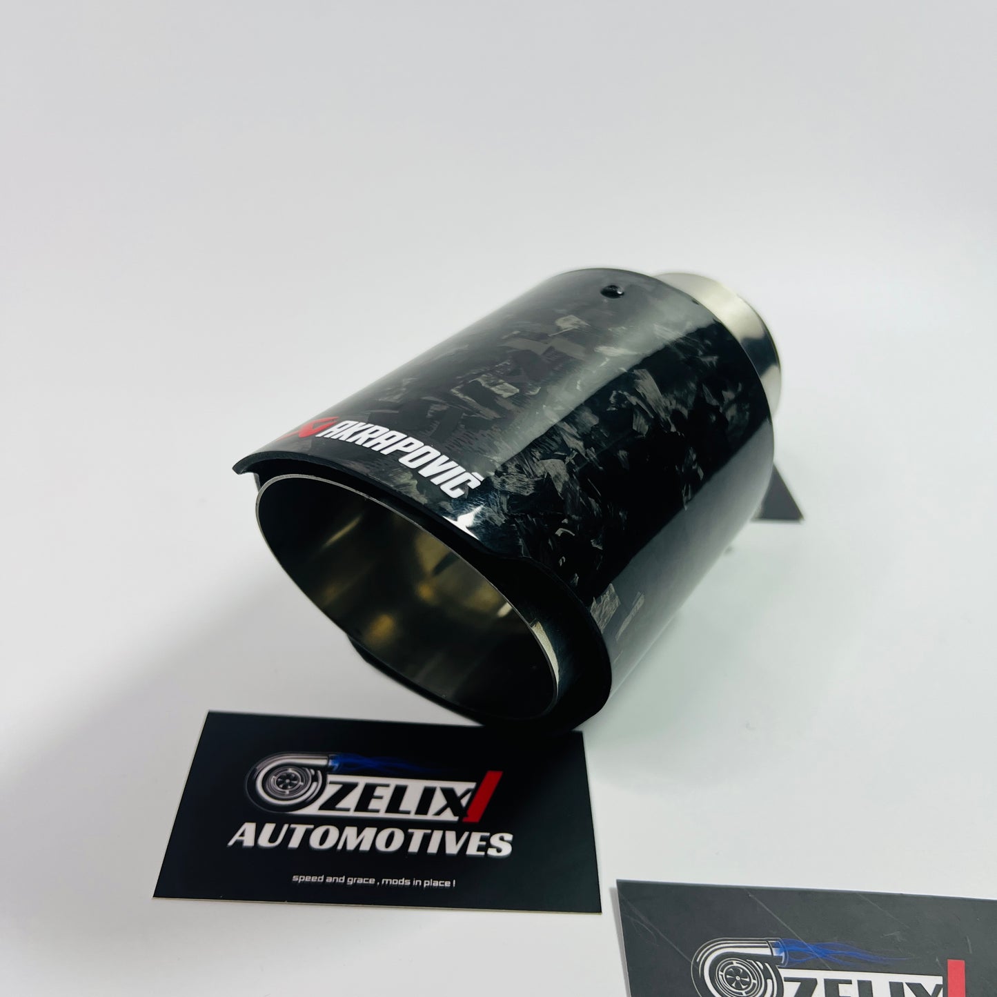 Top-down view emphasizing the oval outlet and intricate carbon fiber pattern