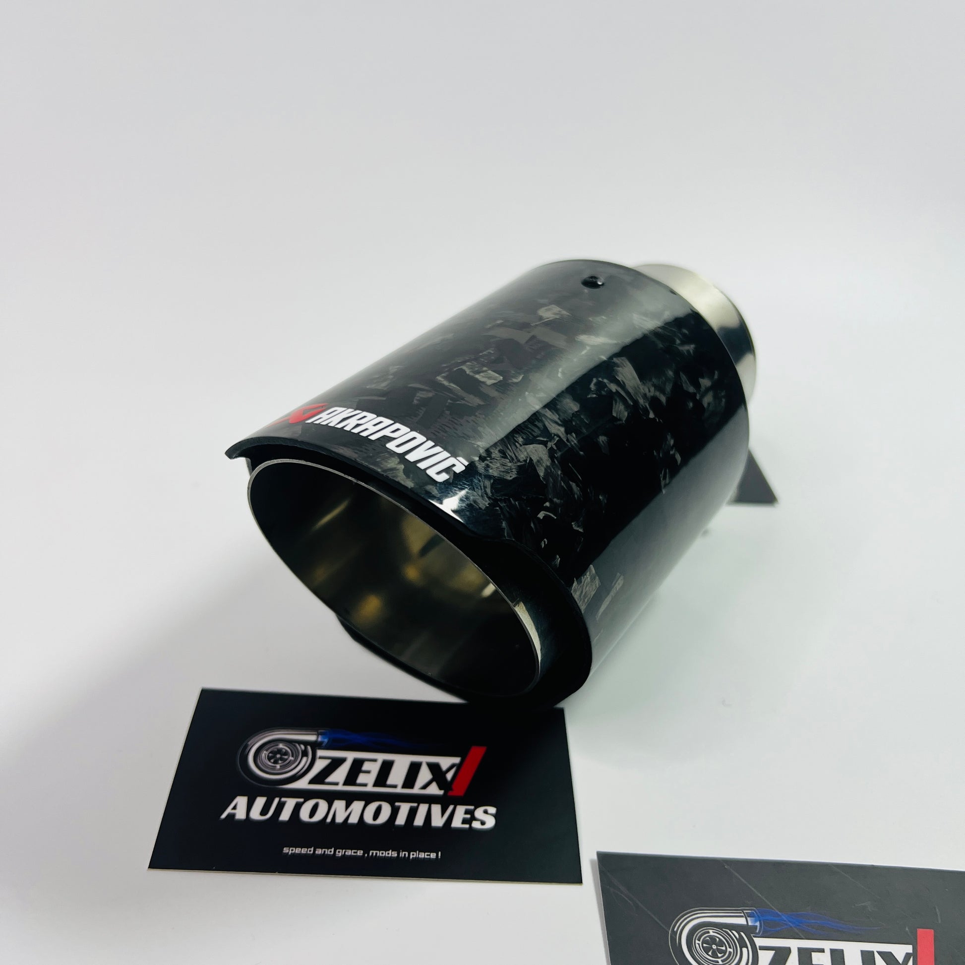 Top-down view emphasizing the oval outlet and intricate carbon fiber pattern