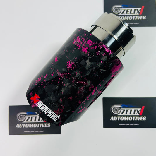 Akrapovic pink forged carbon single exhaust tip shown from the front angle, highlighting its glossy carbon surface and bold coloring.