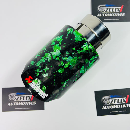 Akrapovic-style green forged carbon single exhaust tip displayed from the front