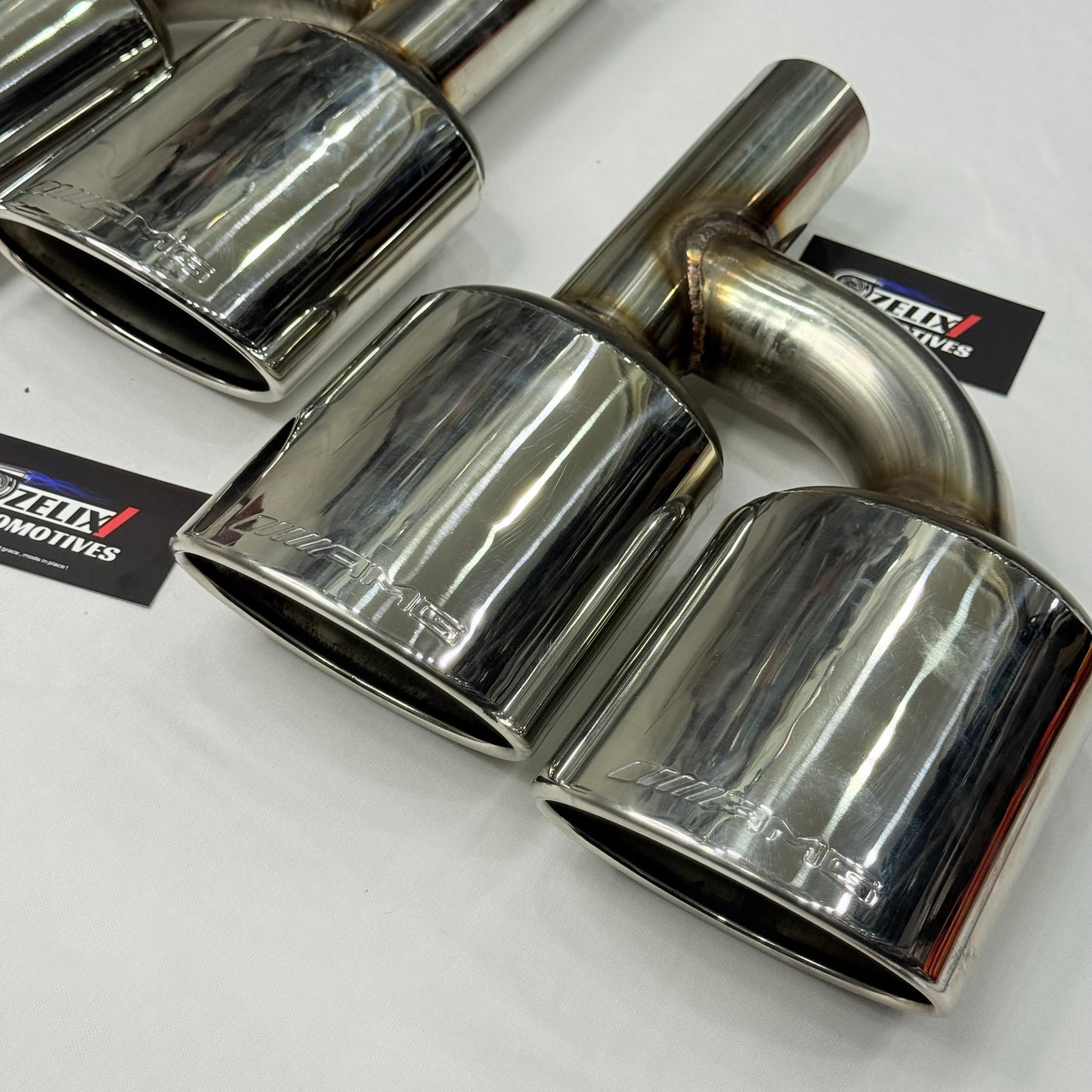 Side profile of AMG-style dual exhaust tip with polished finish