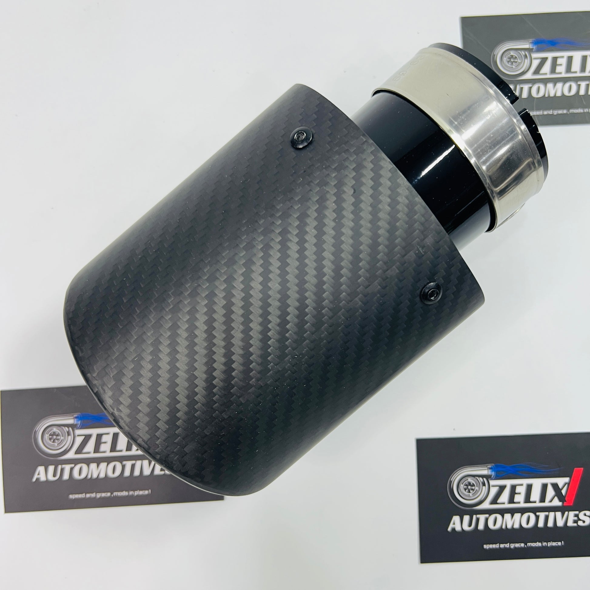 Single tip matte carbon black body exhaust tip shown from the front angle