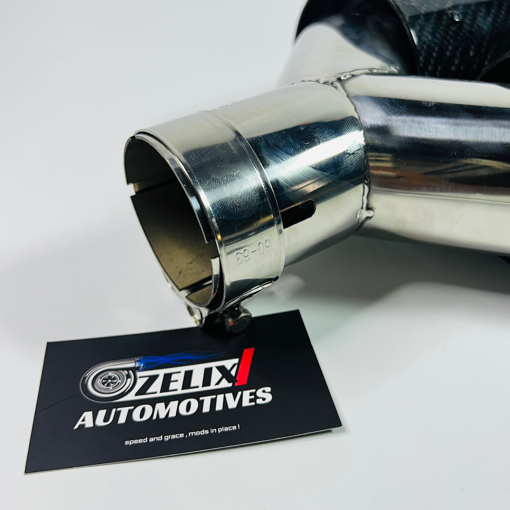 Front close-up of Akrapovic gloss carbon dual exhaust tip
