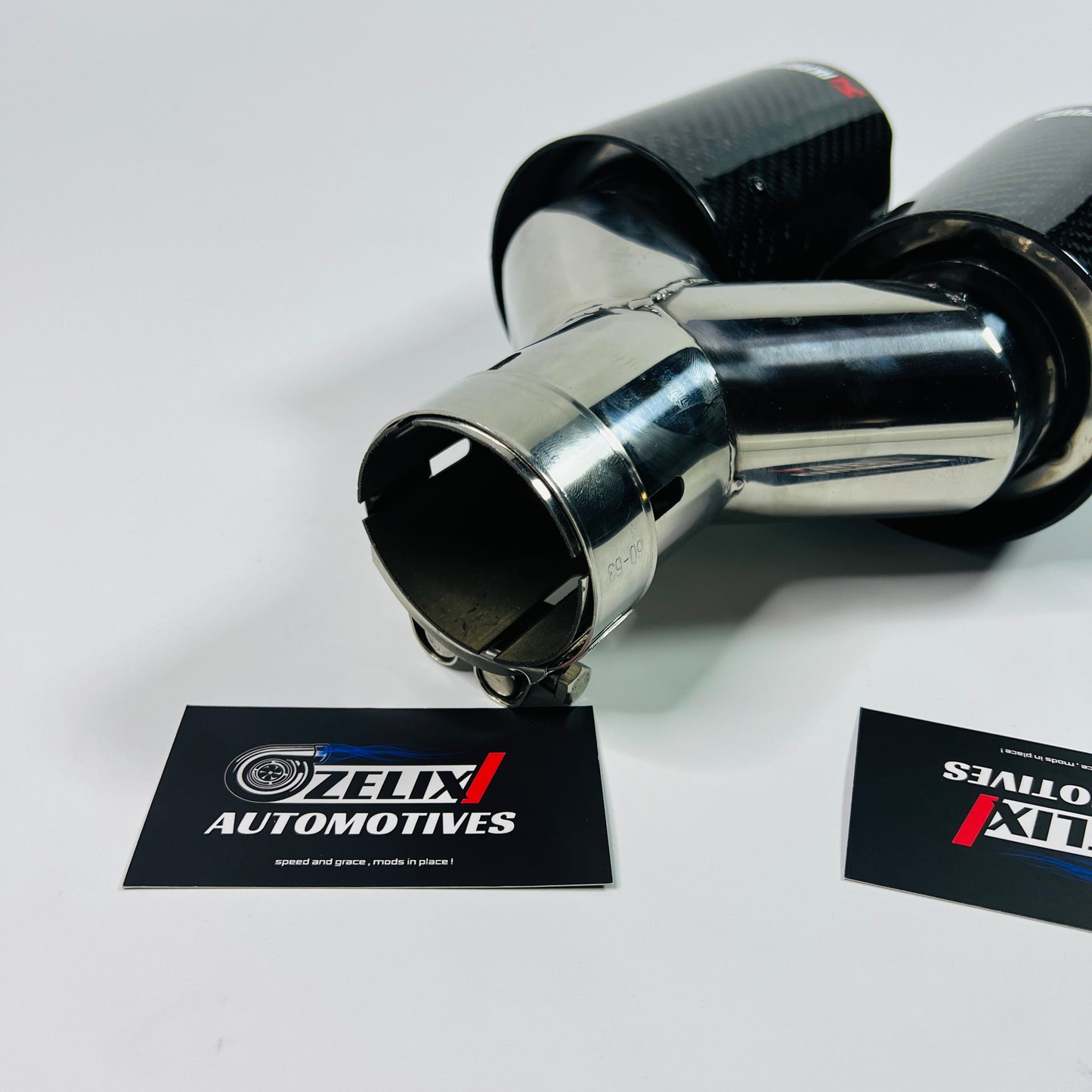 Akrapovic gloss carbon dual exhaust tip on white background
