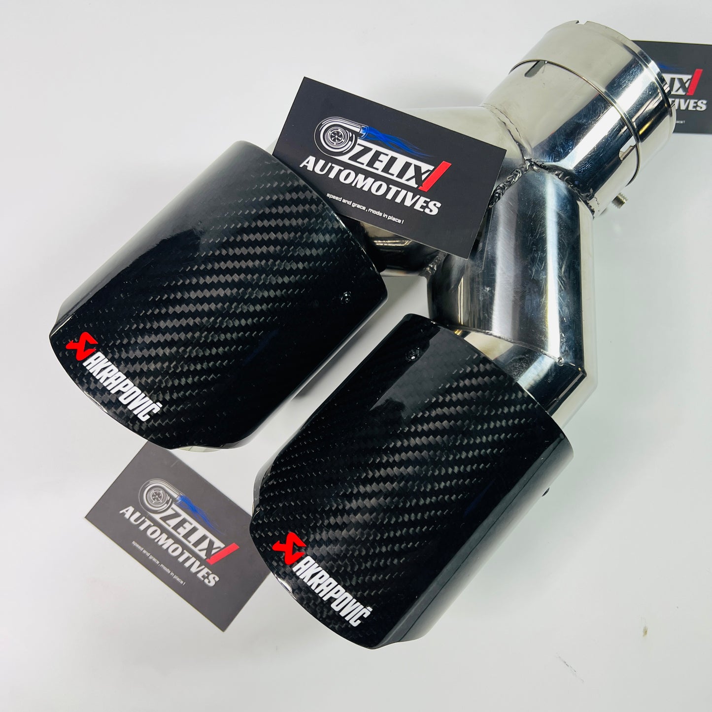 Akrapovic gloss carbon dual exhaust tip on white background