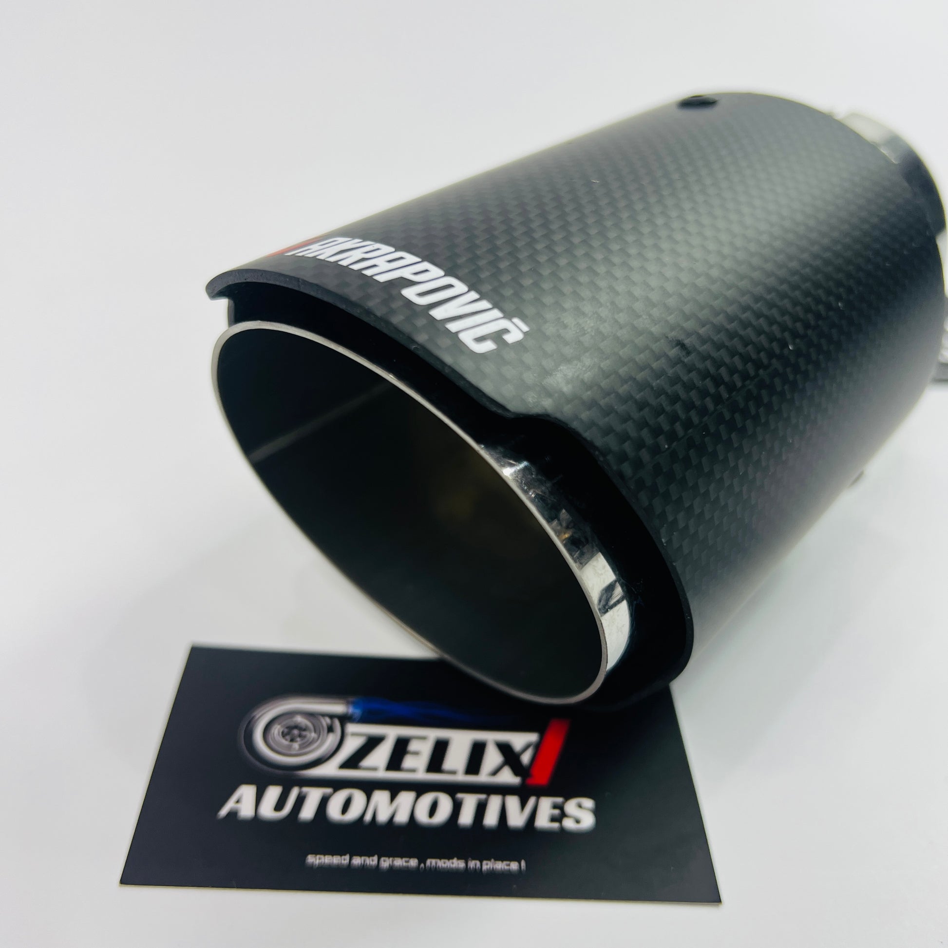 Akrapovic matte carbon single exhaust tip installed on car