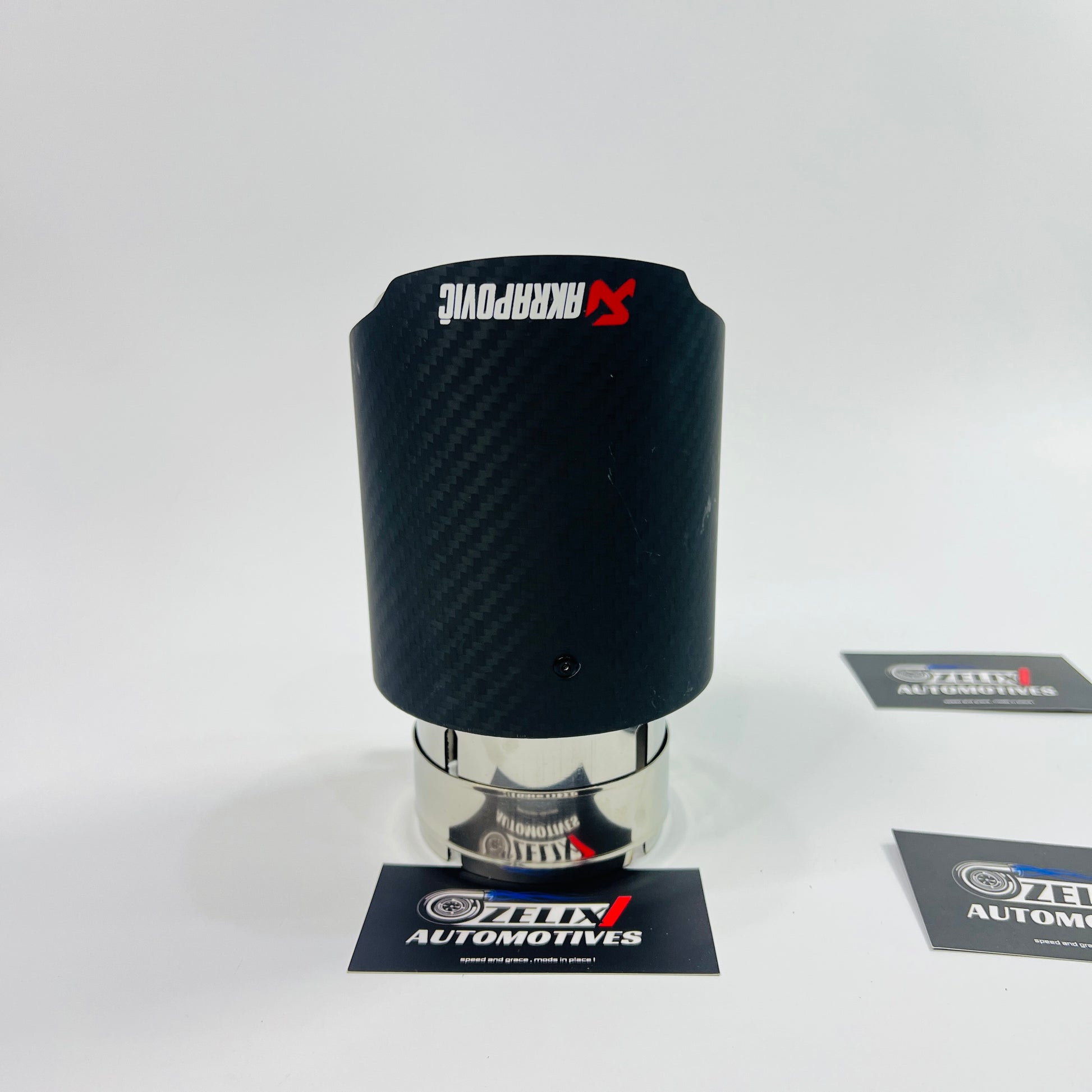 Side view of Akrapovic matte carbon exhaust tip in low light