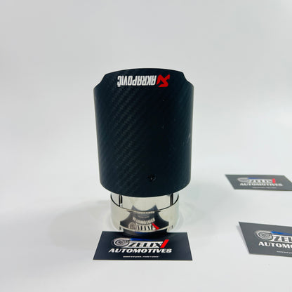 Side view of Akrapovic matte carbon exhaust tip in low light