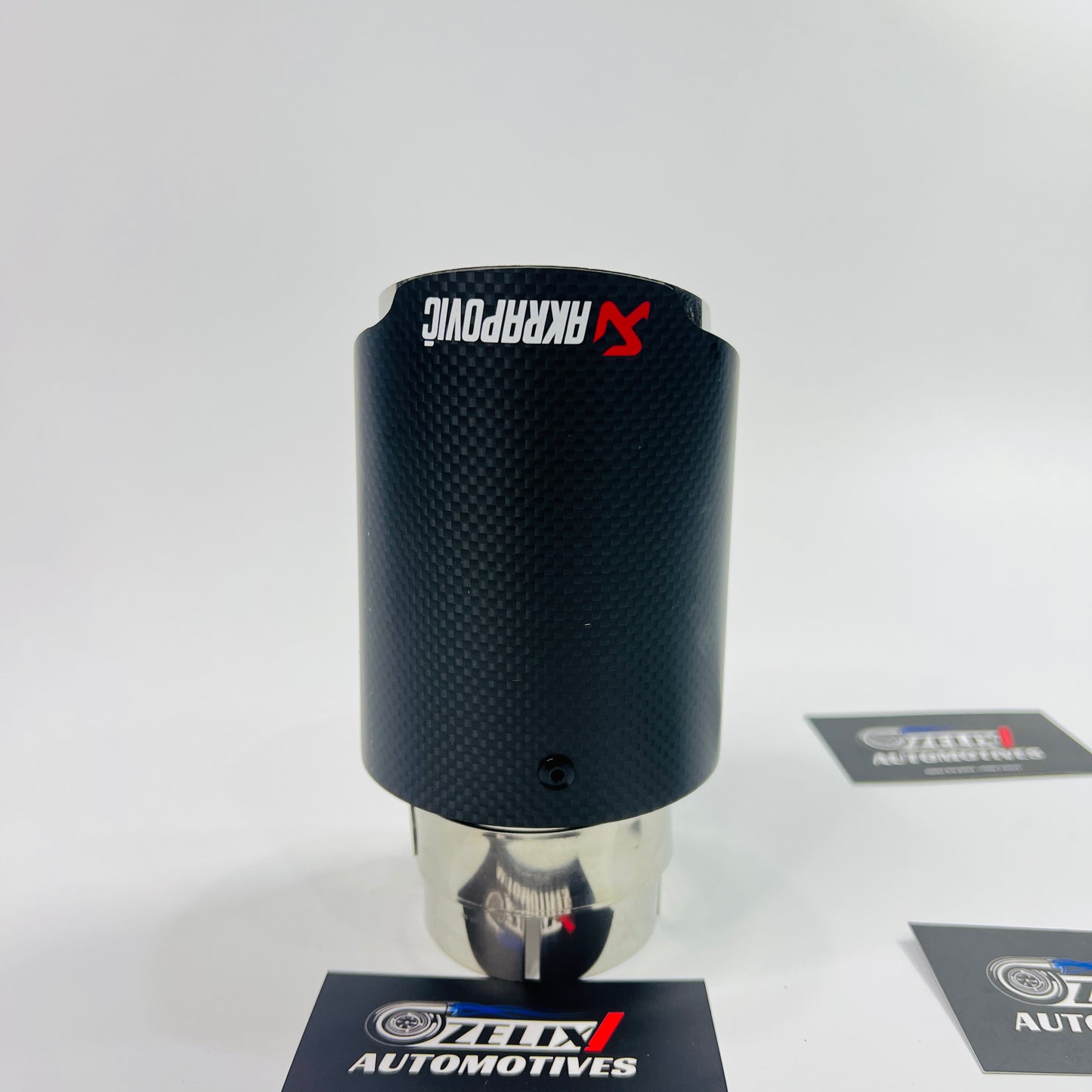 Akrapovic matte carbon single exhaust tip on plain background