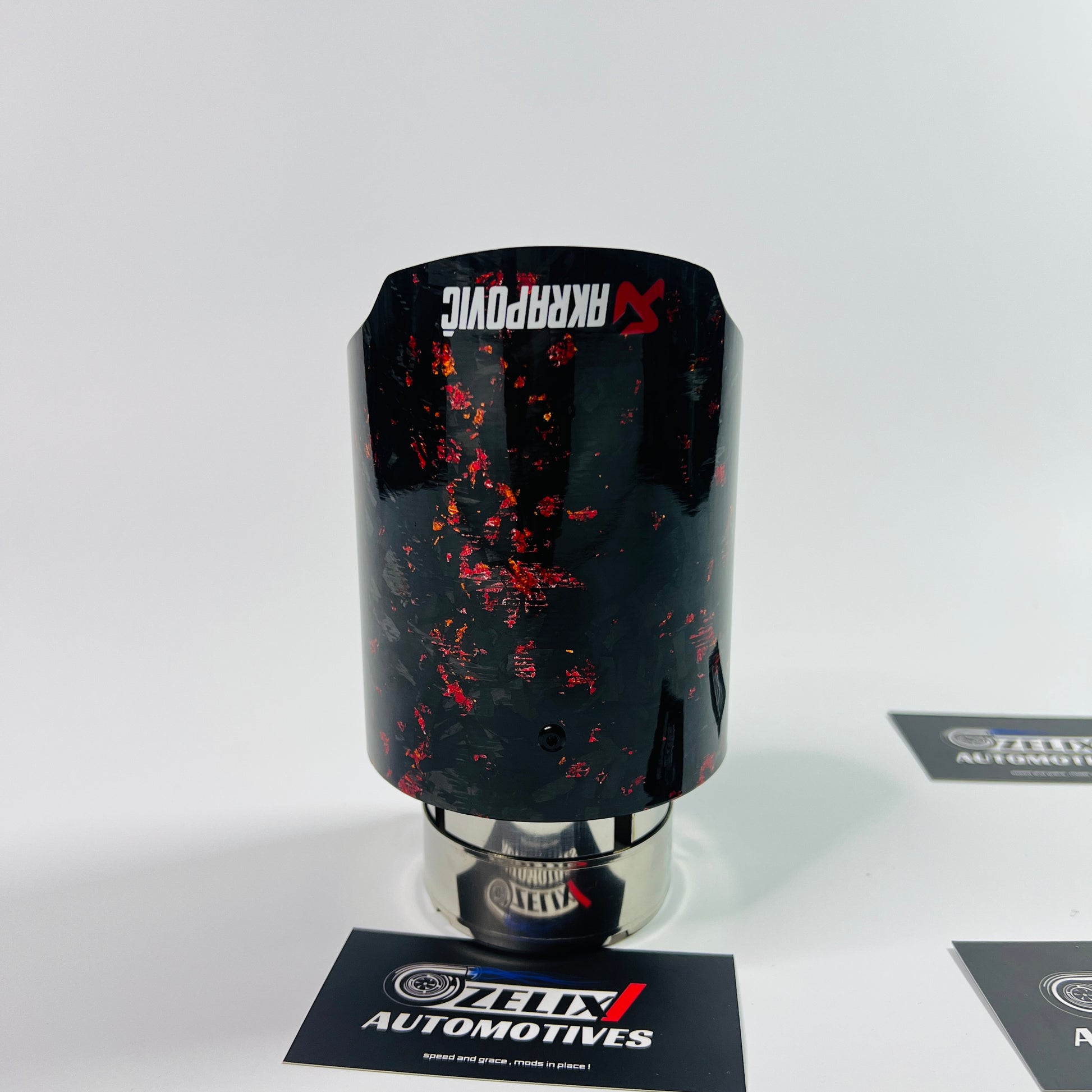 Side view of Akrapovic red forged carbon single exhaust tip
